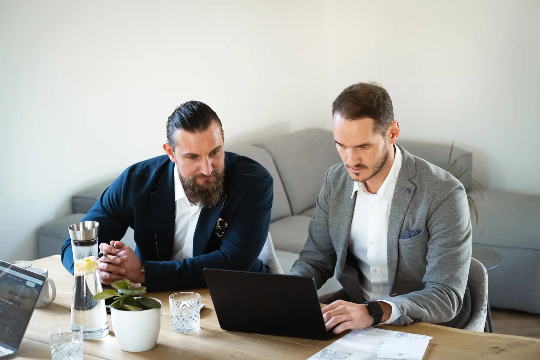 Chris Reinersmann und Sven Najemnik, die Immobilienmakler von Ruhr Casa in Essen, bei der Arbeit am Laptop